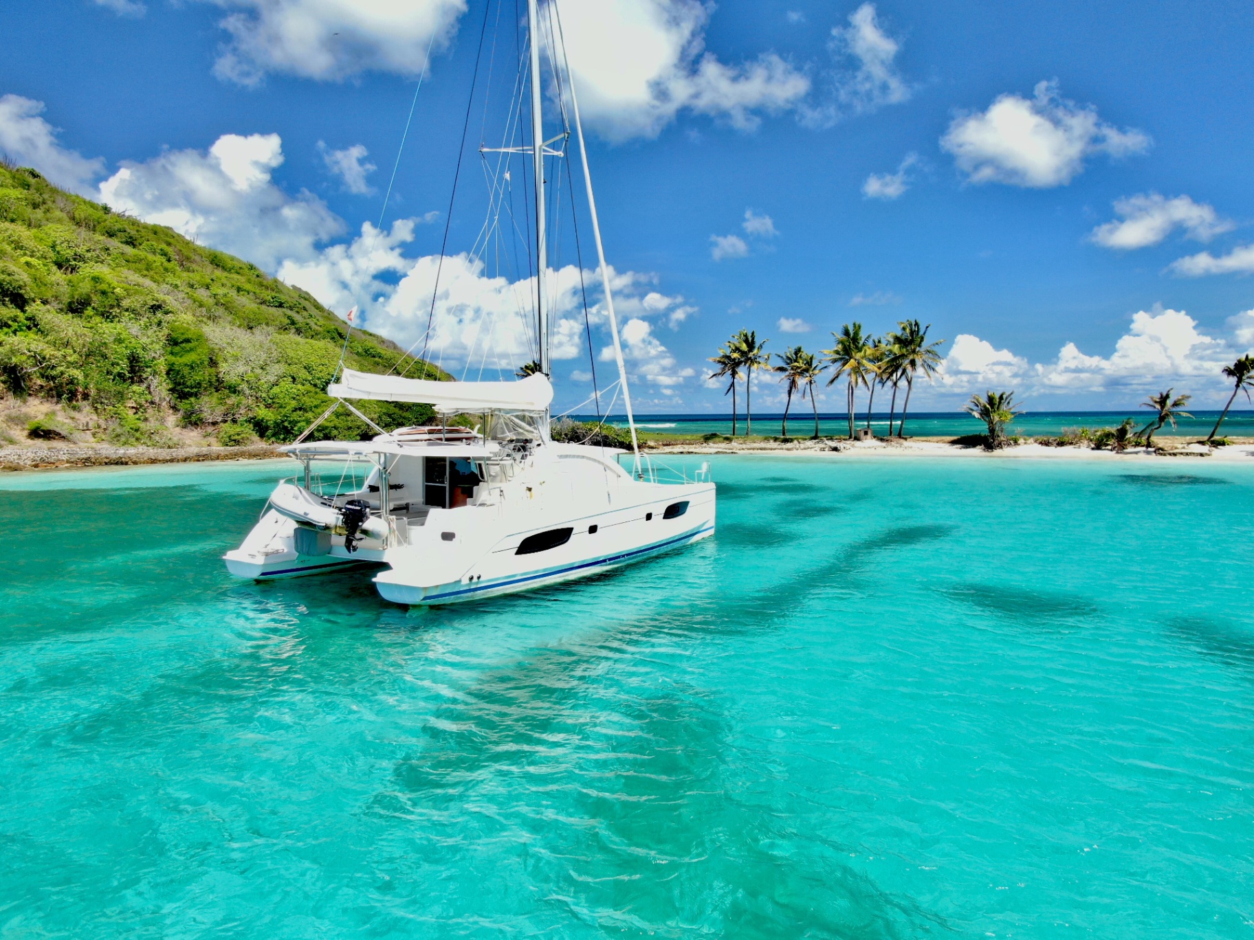 Aerial view of a catamaran sailing turquoise waters in the Grenadines