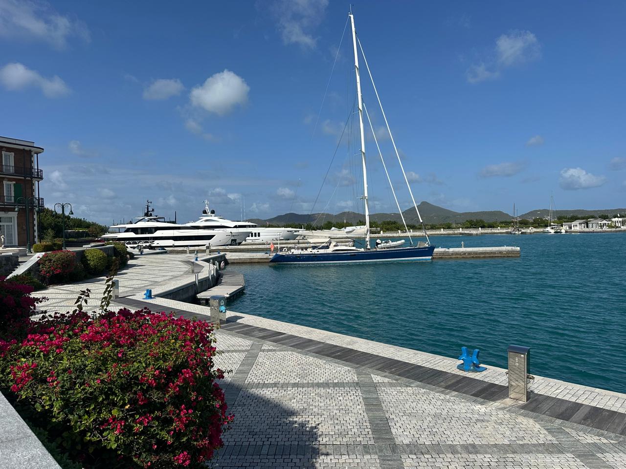 Sailing yacht moored alongside a superyacht at Port Louis Marina, Canouan